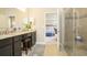 Stylish main bathroom featuring double sinks, a granite countertop, a tile floor, and a glass-enclosed shower at 6552 Rhythm Dr, Mascotte, FL 34753