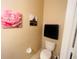 Compact bathroom featuring a toilet, towel rack, and framed decorative art creating an inviting space at 6640 S Goldenrod Rd # 118B, Orlando, FL 32822