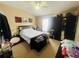 Spacious bedroom with tan carpet, ceiling fan and black furniture and decor at 6640 S Goldenrod Rd # 118B, Orlando, FL 32822