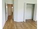 Bright bedroom with wood-look flooring, closet, and doorway leading to the bathroom at 6640 S Goldenrod Rd # 118B, Orlando, FL 32822