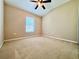 This bedroom offers carpeting, a fan, and a window for natural light to enter the space at 6640 S Goldenrod Rd # 118B, Orlando, FL 32822