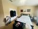 Bedroom with tan carpet and neutral walls showcasing decor on walls, a bed and white closet at 6640 S Goldenrod Rd # 118B, Orlando, FL 32822