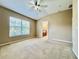 Bedroom featuring neutral carpeting, a ceiling fan, and a large window for natural light at 6640 S Goldenrod Rd # 118B, Orlando, FL 32822