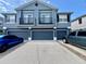 Three-story townhouse with three garages and balconies, painted in gray tones, and driveway at 6640 S Goldenrod Rd # 118B, Orlando, FL 32822