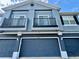 Townhouse exterior featuring a blue paint scheme, two balconies, and an attached garage at 6640 S Goldenrod Rd # 118B, Orlando, FL 32822
