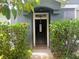 Charming entryway with dark wood door, a welcome mat and lush green landscaping, creating a warm invitation at 6640 S Goldenrod Rd # 118B, Orlando, FL 32822