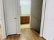 View from the hallway leading into a bathroom, featuring wood-look floors and white trim at 6640 S Goldenrod Rd # 118B, Orlando, FL 32822