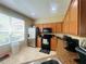 Kitchen with wood cabinets, granite counters, stainless refrigerator and tile floors at 6640 S Goldenrod Rd # 118B, Orlando, FL 32822