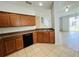 Kitchen features wood cabinets and black appliances, ceramic flooring, and an open view to the living area at 6640 S Goldenrod Rd # 118B, Orlando, FL 32822