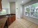 Kitchen featuring wood cabinets, brown countertops, ceramic tiled floor, and a view to the breakfast area at 6640 S Goldenrod Rd # 118B, Orlando, FL 32822
