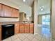 Bright kitchen showcasing wood cabinets, laminate counters, and an open view to the living room at 6640 S Goldenrod Rd # 118B, Orlando, FL 32822