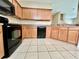 View of the kitchen featuring wood cabinets, black appliances, and tile flooring at 6640 S Goldenrod Rd # 118B, Orlando, FL 32822