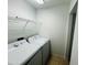 Convenient laundry room with washer, dryer, and overhead shelving for easy storage at 6640 S Goldenrod Rd # 118B, Orlando, FL 32822