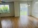 Living room displaying wood flooring and natural light through a sliding door and window at 6640 S Goldenrod Rd # 118B, Orlando, FL 32822