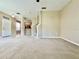 View of the living room showcasing carpet, stairs, entry door, and view to kitchen at 6640 S Goldenrod Rd # 118B, Orlando, FL 32822