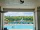 A view of the pool featuring lounge chairs, a fountain, and a glimpse of lush green trees at 6640 S Goldenrod Rd # 118B, Orlando, FL 32822