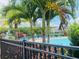 A pool featuring a fountain, lounge chairs, mature palms and lush greenery, with townhomes in the distance at 6640 S Goldenrod Rd # 118B, Orlando, FL 32822