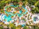 Aerial view of resort with multiple pools, water features, palm trees, and lounge areas at 7691 Heritage Crossing Way # C-1, Reunion, FL 34747