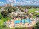 Expansive aerial shot of resort featuring pool, clubhouse, and lush landscaping at 7691 Heritage Crossing Way # C-1, Reunion, FL 34747