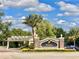 Reunion Resort entrance featuring lush landscaping and clear blue skies, with a palm tree at 7691 Heritage Crossing Way # C-1, Reunion, FL 34747