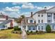 Charming blue and white townhouse with well-manicured landscaping under a sunny sky with cloudscape at 7691 Heritage Crossing Way # C-1, Reunion, FL 34747