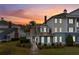 Charming two-story townhome featuring a beautifully landscaped front yard and inviting entrance at sunset at 7691 Heritage Crossing Way # C-1, Reunion, FL 34747