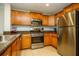 Functional kitchen features stainless steel appliances, wood cabinets, and granite countertops at 7691 Heritage Crossing Way # C-1, Reunion, FL 34747