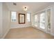 Light-filled room with hardwood floors, decorative mirror and sliding glass doors to a balcony at 7691 Heritage Crossing Way # C-1, Reunion, FL 34747