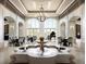 Grand lobby with a stunning chandelier, fountain, and elegant seating areas by arched windows and doors at 7691 Heritage Crossing Way # C-1, Reunion, FL 34747