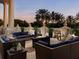 Stylish outdoor patio with comfortable seating, a modern fire pit, and scenic views of palm trees at 7691 Heritage Crossing Way # C-1, Reunion, FL 34747