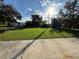 Expansive front yard features lush green grass, mature trees, and plenty of space at 803 N Pine Hills Rd, Orlando, FL 32808