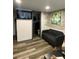 Relaxing living room features a sleek black couch, television, and modern brick accent wall at 803 N Pine Hills Rd, Orlando, FL 32808