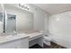 Bathroom featuring a single sink vanity, an oversized mirror, and shower over tub at 824 Washington Palm Loop, Davenport, FL 33897