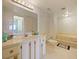 Bright bathroom featuring a marble countertop, white cabinets and a luxurious soaking tub at 901 S Atlantic Ave # 5, Ormond Beach, FL 32176