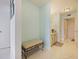 Hallway with light blue walls, tile floors, and a cushioned bench with decor art at 901 S Atlantic Ave # 5, Ormond Beach, FL 32176