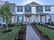 Beautifully designed townhome with gray and white exterior, lush landscaping, and a welcoming walkway to the front door at 9338 Bolshoi Aly, Winter Garden, FL 34787
