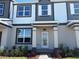 Charming townhome showcasing modern gray and white exterior with a well-manicured lawn and inviting entrance at 9338 Bolshoi Aly, Winter Garden, FL 34787