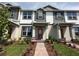Charming townhome showcases a well manicured lawn and a welcoming front entrance with a red front door at 9338 Bolshoi Aly, Winter Garden, FL 34787