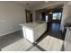Bright kitchen island with light countertop, sink, and storage, complemented by tile flooring and open living space at 9338 Bolshoi Aly, Winter Garden, FL 34787