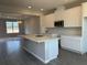 Spacious open-concept kitchen with white cabinets, stainless steel appliances, tile floors, and large center island at 9338 Bolshoi Aly, Winter Garden, FL 34787