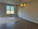 Empty living room with tile flooring, large window, and modern light fixture, awaiting customization at 9338 Bolshoi Aly, Winter Garden, FL 34787