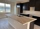 This kitchen features dark cabinetry and a stainless sink in a center island at 9356 Bolshoi Aly, Winter Garden, FL 34787