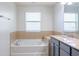 Bright bathroom features a soaking tub with tile accents, vanity, and a large window at 9575 Silver Buttonwood St, Orlando, FL 32832