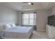 Bright bedroom featuring a ceiling fan, tray ceiling, light wood floors, and a large window at 9575 Silver Buttonwood St, Orlando, FL 32832