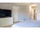 View of a bedroom with a TV on a dresser, light wood floors and a doorway to another room at 9575 Silver Buttonwood St, Orlando, FL 32832