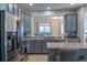 Modern kitchen with gray cabinets, stainless steel appliances, and a serving hatch looking into the living area at 9575 Silver Buttonwood St, Orlando, FL 32832