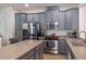 Kitchen showcasing gray cabinetry, stainless steel appliances, and a spacious island with granite countertops at 9575 Silver Buttonwood St, Orlando, FL 32832