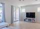 Bright living room featuring tile floors, large windows, a sliding door, and a media center at 9575 Silver Buttonwood St, Orlando, FL 32832