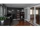 A home office with a decorative rug, wood floors and a black accent wall with shelving at 1021 Carlson Dr, Orlando, FL 32804