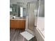 Bright bathroom featuring a glass shower, soaking tub, wood cabinets, and stylish decor at 1117 Cambourne Dr, Kissimmee, FL 34758